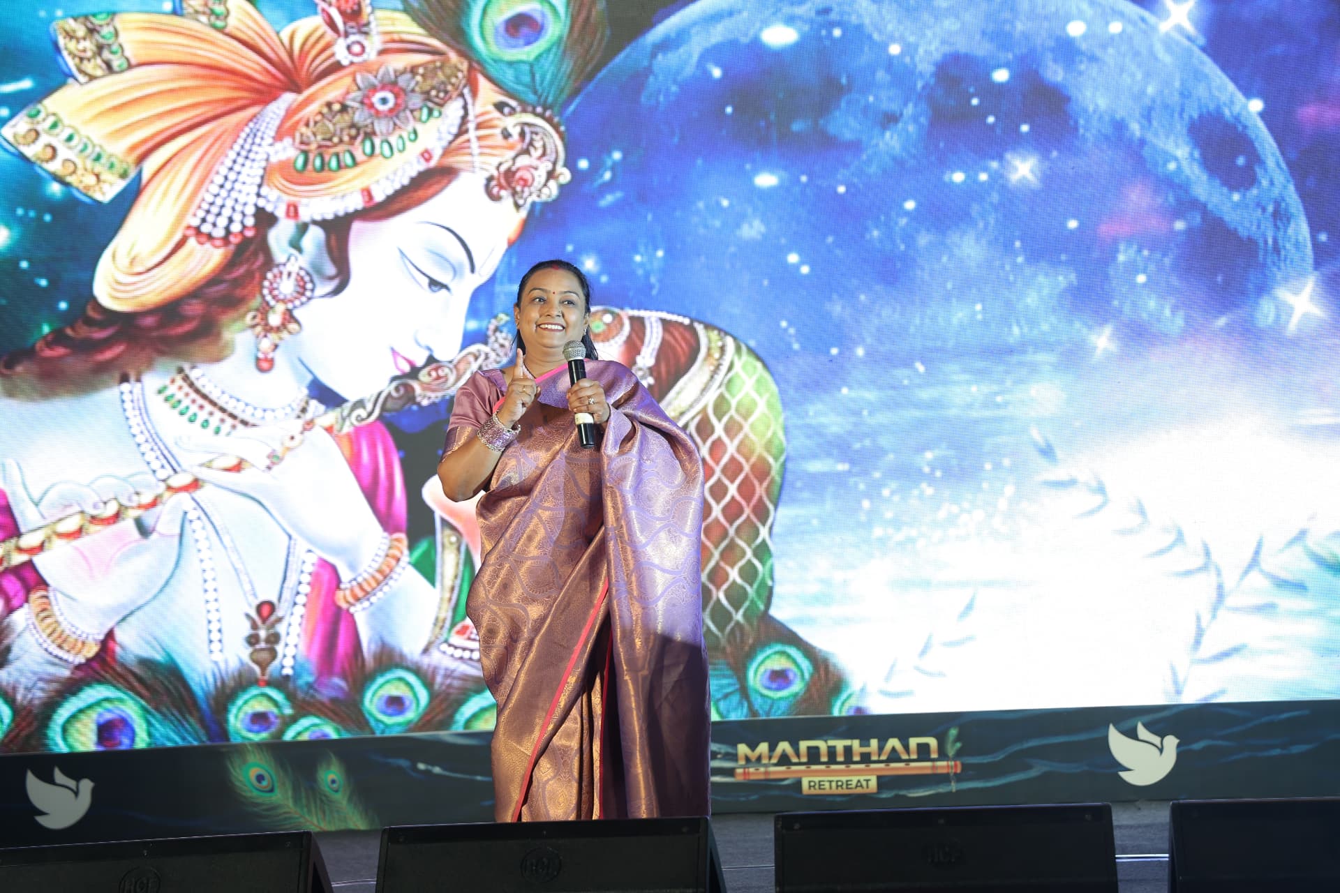 Raksha Singh speaking on stage with a microphone